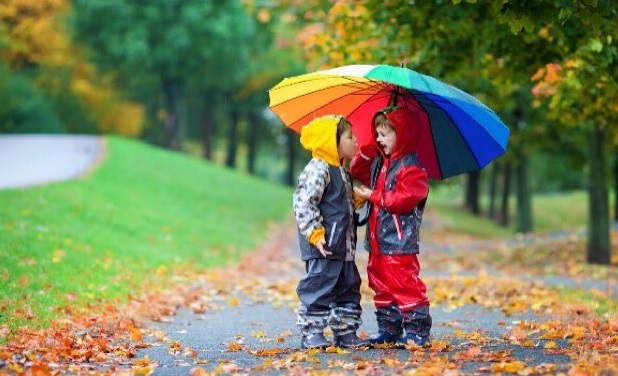 بازی کودکان با چتر رنگین کمانی
